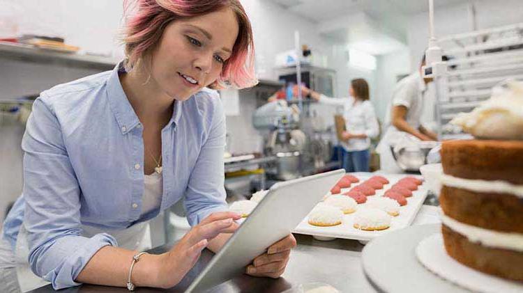 面包店老板在iPad上查看小企业的退休计划.
