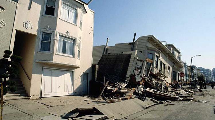 Houses with earthquake damage w在这里 one is leaning to the left and sunk in.