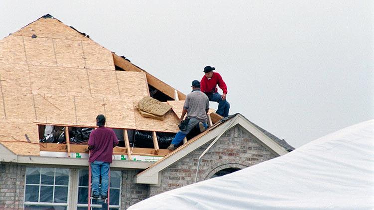 承包商在暴风雨损坏后更换屋顶.