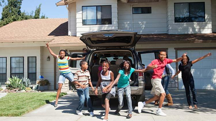 6个孩子在一辆敞篷SUV前兴奋地跳着.