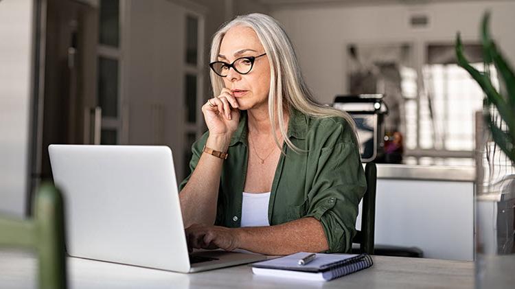 女人坐在笔记本电脑前，回顾她的遗产计划.